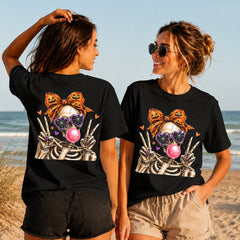 Bubblegum Skeleton - Women's T-Shirt in black, showing alternative back and front print placements on the beach