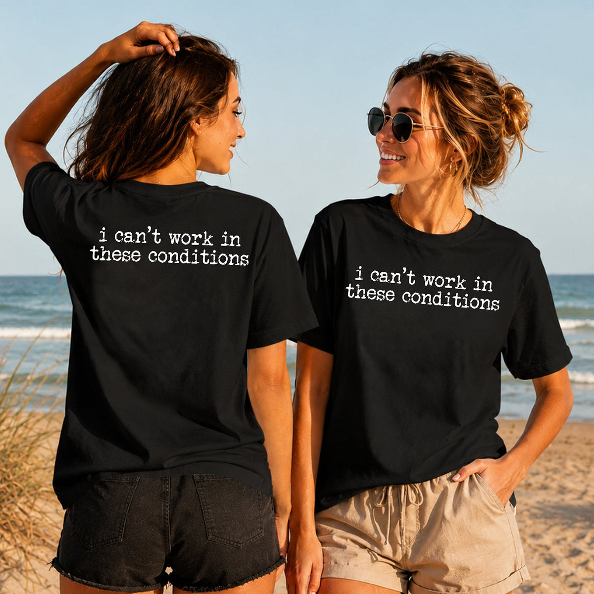Can't Work in These Conditions - Women's T-Shirt in black, showing alternative back and front print placements on the beach