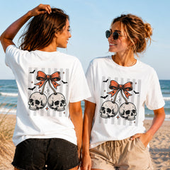 Halloween Skull Cherries - Women's T-Shirt in white, showing alternative back and front print placements on the beach