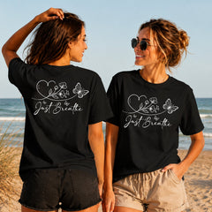Just Breathe - White Butterfly - Women's T-Shirt in black, showing alternative back and front print placements on the beach