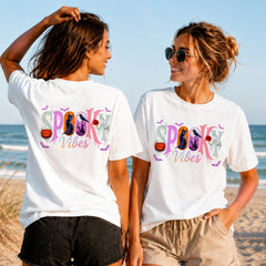Spooky Vibes Pastel - Women's T-Shirt in white, showing alternative back and front print placements on the beach
