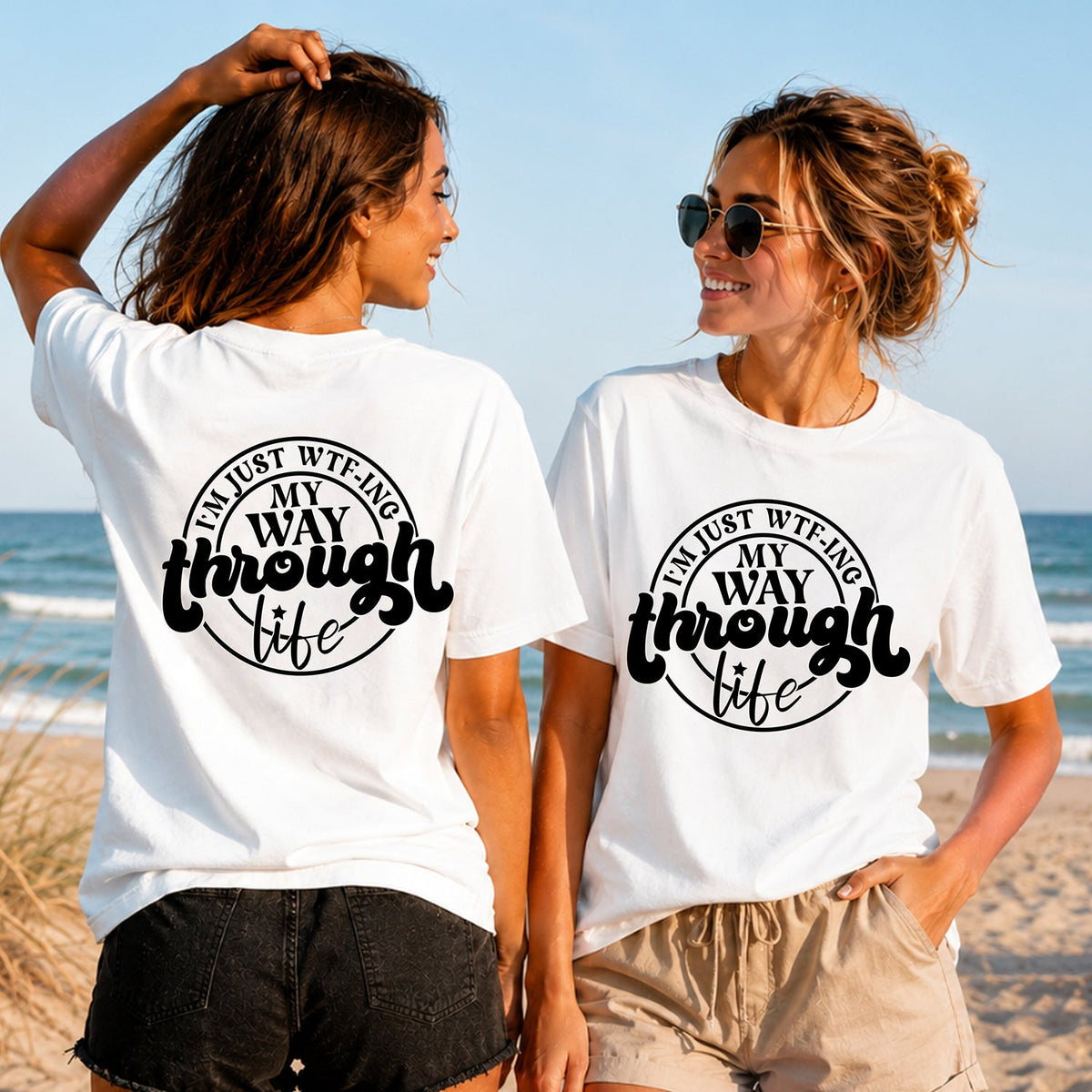WTF-ing Through Life - Black - Women's T-Shirt in white, showing alternative back and front print placements on the beach