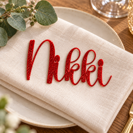 Nikki in Anytimes font, Bright Red Glitter Acrylic personalised guest name on an ivory napkin.
