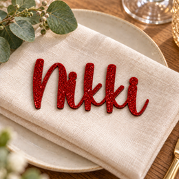 Nikki in Awesome Snowflake font, Bright Red Glitter Acrylic personalised guest name on an ivory napkin.