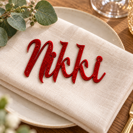 Nikki in Eaglese Pro font, Bright Red Glitter Acrylic personalised guest name on an ivory napkin.