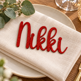 Nikki in Lucky font, Bright Red Glitter Acrylic personalised guest name on an ivory napkin.