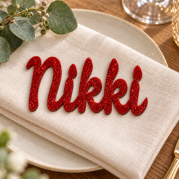 Nikki in Ramla font, Bright Red Glitter Acrylic personalised guest name on an ivory napkin.