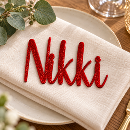 Nikki in Relaytemore font, Bright Red Glitter Acrylic personalised guest name on an ivory napkin.