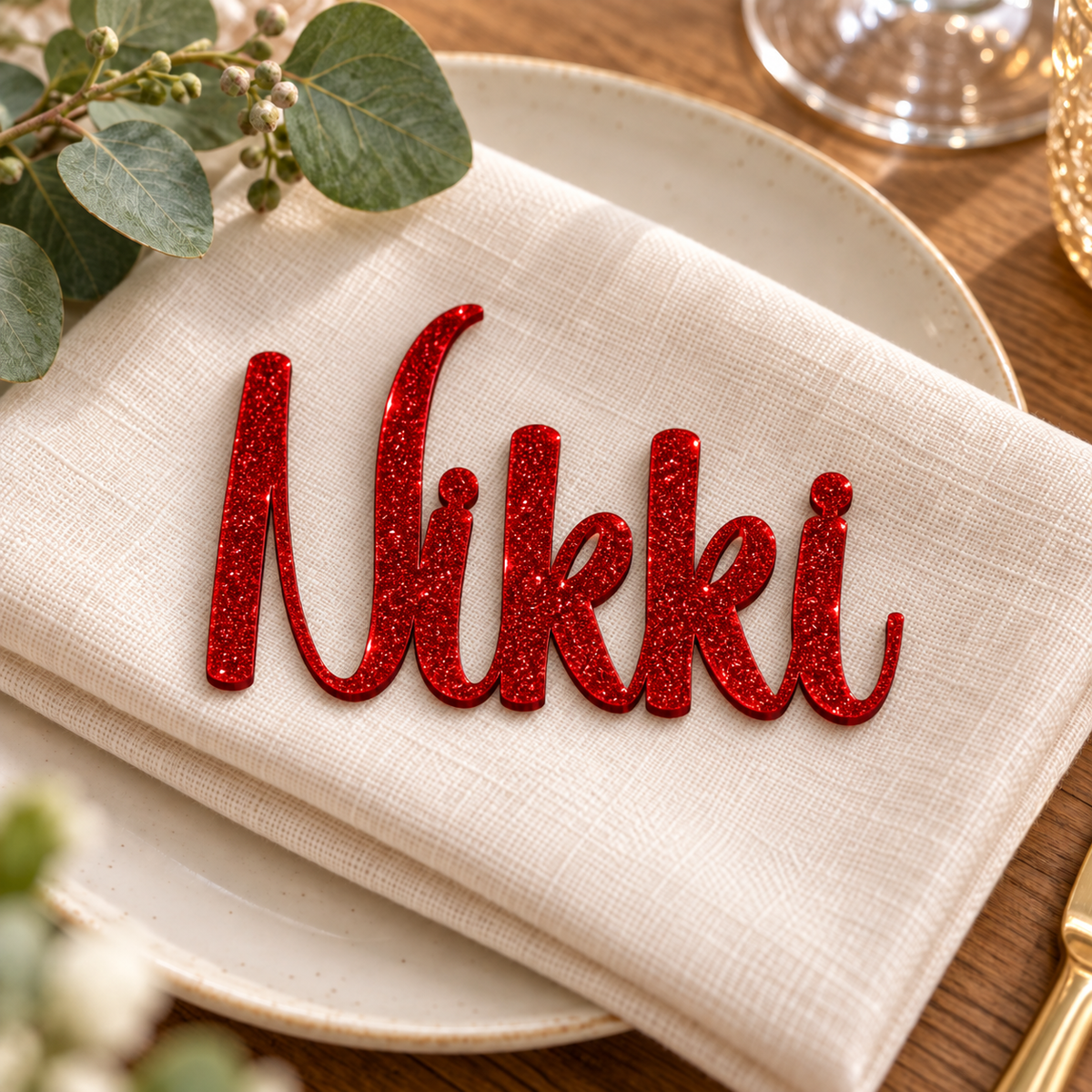 Nikki in Writing Monogram font, Bright Red Glitter Acrylic personalised guest name on an ivory napkin.