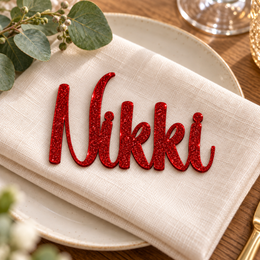 Nikki in Writing Monogram font, Bright Red Glitter Acrylic personalised guest name on an ivory napkin.
